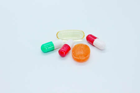 Multi-colored pills are located on a white background