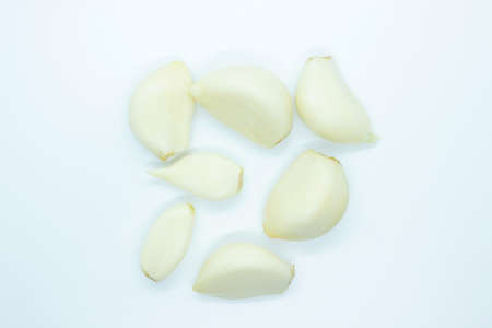 Peeled garlic located on a white backgroundの写真素材