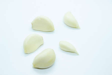 Ripe peeled garlic perched on a white backgroundの写真素材