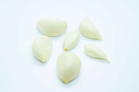 Ripe peeled garlic perched on a white backgroundの写真素材