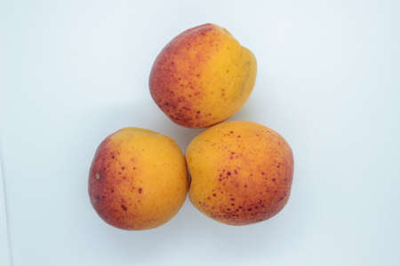 Ripe beautiful apricots are located on a white backgroundの写真素材