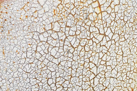 White cracked paint is applied to a rusty surfaceの写真素材