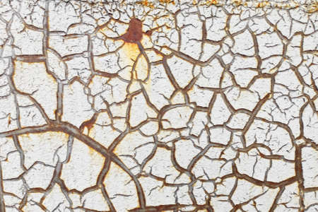 White cracked paint is applied to a rusty surfaceの写真素材