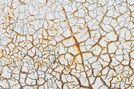 White cracked paint is applied to a rusty surfaceの写真素材