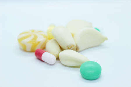 Garlic, vitamins, pills laid on a white backgroundの写真素材