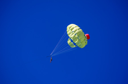 Two people on the parachute in the blue sky