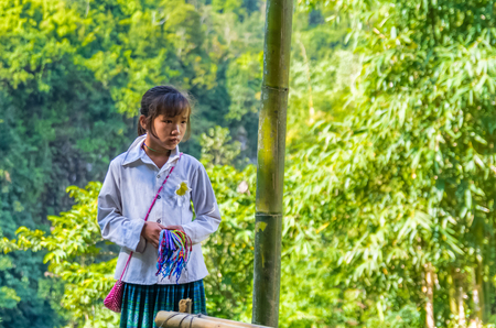 SAPA, VIETNAM - NOVEMBER 16: Vietnamese girl from Hmong ethnic minority group trading handmade souvenirs at November 16, 2016 in Sapa, Vietnamのeditorial素材