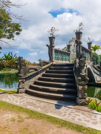 View of bridge in park in Tirta Gangga temple at sunny day in Bali, Indonesiaの写真素材