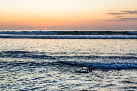Amazing sunset view on Indian ocean from Suluban beach at Bali, Indonesiaの写真素材