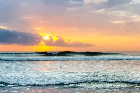 Amazing sunset view on Indian ocean from Suluban beach at Bali, Indonesiaの写真素材