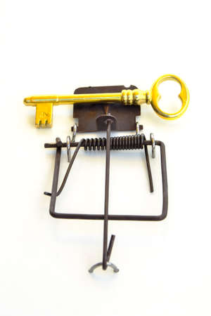 GOLD KEY ON A MOUSETRAP - Mousetrap with a gold house key as a bait.の写真素材