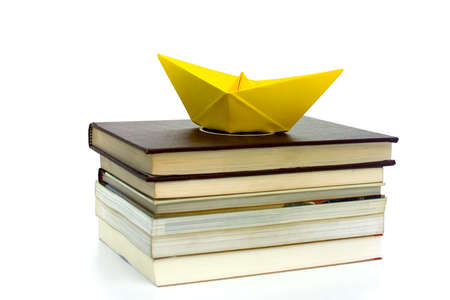 WITH A BOOK YOU CAN TRAVEL 1-An origami boat shipping through the books.の写真素材