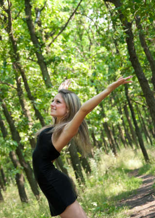 Young woman open hands standing on forestの写真素材