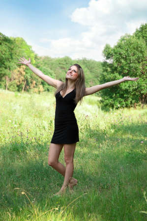 Young woman open hands standing on fieldの写真素材