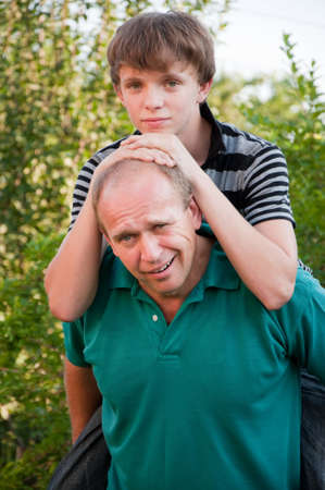 Father giving his son piggybackの写真素材