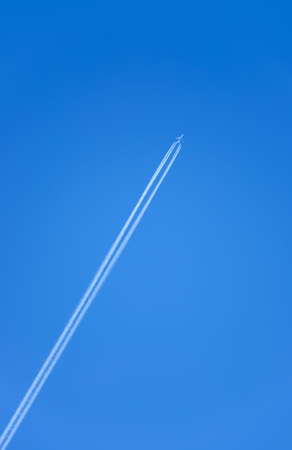Commercial jet airplane with a white condensation traceの写真素材