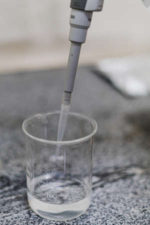 hand with gray glove using laboratory equipmentの写真素材