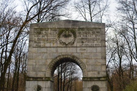 Historic stone arch with Russian and German inscriptions at the Soviet War Memorial in Treptower Park, Berlin. A solemn landmark commemorating World War II heroes.の写真素材