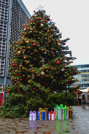 Christmas tree with red and gold ornaments and illuminated gift boxes at Breitscheidplatz in Berlin Germany during holiday season, festive urban scene and landmark.の写真素材