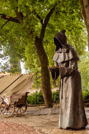 Bronze sculpture of a hooded monk standing under trees in the Danish King's Garden, a historical park in Tallinn old town, Estonia.の写真素材
