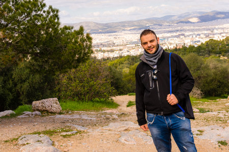 Man standing at Pnyx Hill with panoramic city view of Athens, Greece.の写真素材