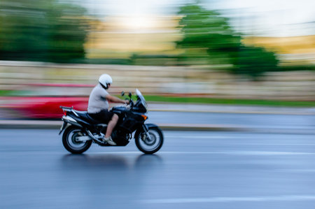 Motorcycle rider with helmet on city street in Athens, Greece.の写真素材