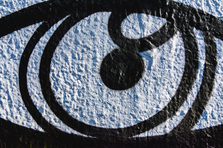 Closeup of black eye graffiti street art on textured wall in Athens, Greece.の写真素材