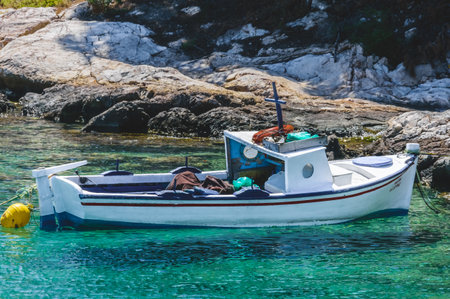 Traditional fishing boat floating in crystal waters at Pachi, Megara, Greece.の写真素材