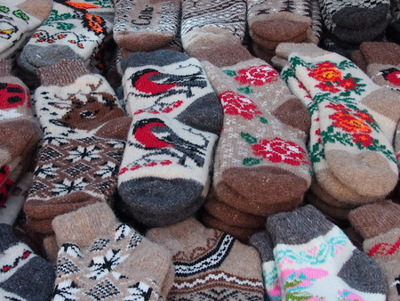 Multi-colored knitted woolen socks are made by national needlewomen for sale at a fairの写真素材