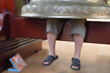The tourist who has climbed under a bell