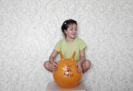 Pretty girl jumps on rubber sports ball with handlesの写真素材