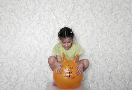 Pretty girl jumps on rubber sports ball with handlesの写真素材