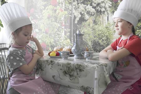 A young chef prepares a festive table for a tea partyの写真素材