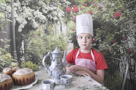 A young chef prepares a festive table for a tea partyの写真素材