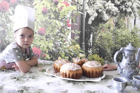 A young chef prepares a festive table for a tea partyの写真素材