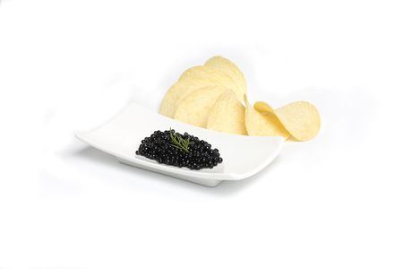 Black caviar with dill in plate and potato chip の写真素材