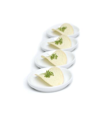 Potato crisps with herbs on plateの写真素材