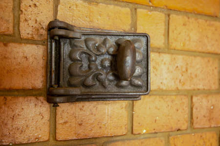 A small door on a mantelpiece made of bricks. Made of cast iron, with a pattern. Chimney doorの写真素材