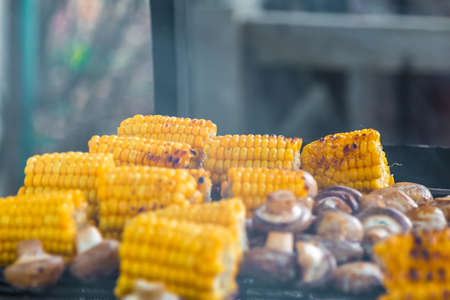 BBQ Champignon mushrooms and corn grilled on grill smokeの写真素材
