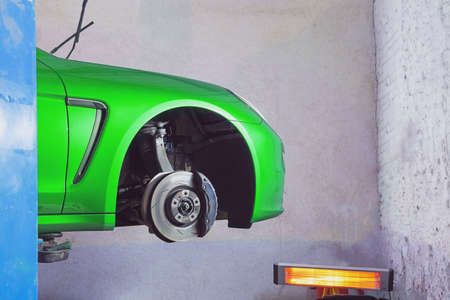 Neon green sportcar in the service station for tire and wheel replacementの写真素材