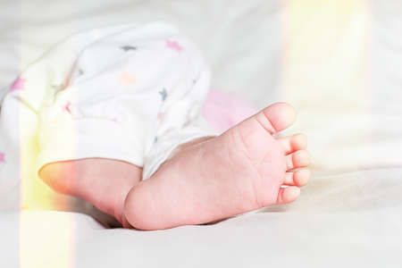 Cute little baby sleeping on bed at home. little baby feetの写真素材