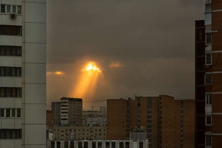 An unusual phenomenon in the sky over the residential area of a big city. The sun's rays make their...