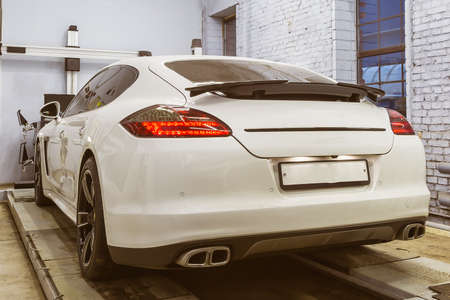 White car, sports executive class sedan on the stand convergence collapse in the service center. In...