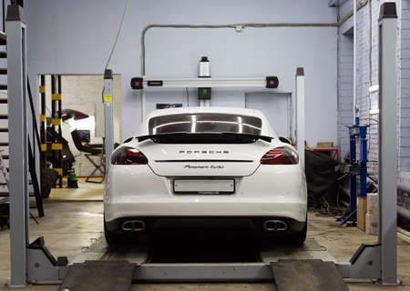 Moscow. November 2018. White Porsche Panamera at the wheel alignment stand of the service center. Sports Porsche, executive class sedan in the tuning and repair center.のeditorial素材