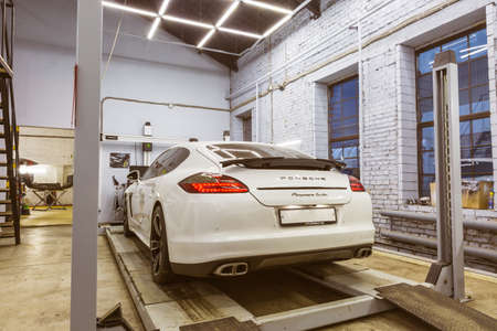 Moscow. November 2018. White Porsche Panamera at the booth of the collapse of the service center. Sports Porsche, executive class sedan in the tuning and repair center.のeditorial素材