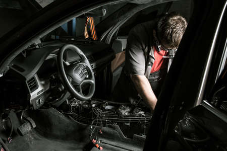 Moscow. November 2018. A mechanic repairs an Audi ... Repairing wiring, gearboxes, disassembled...