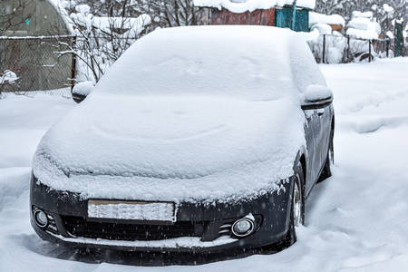 Black dirty car under the snow. Heavy snowfall. Frozen car in snowdrift. winter problems to start engineの写真素材