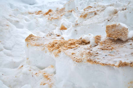 Wooden sawdust under the snow. Filings in snowdrift. Winter texture closeupの写真素材