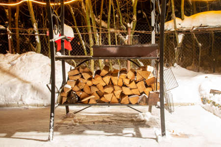 Birch firewood prepared for bbq. Are lying under the grill in snow. Winter nightの写真素材