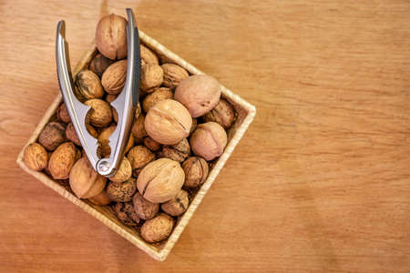 walnuts and nutcracker in bowl. on a wooden background.の写真素材